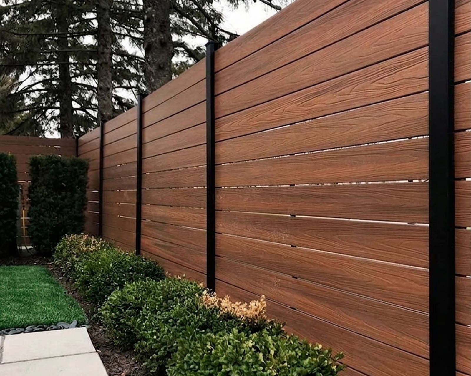 Muro divisorio de lámina con acabado madera, con jardín al pie