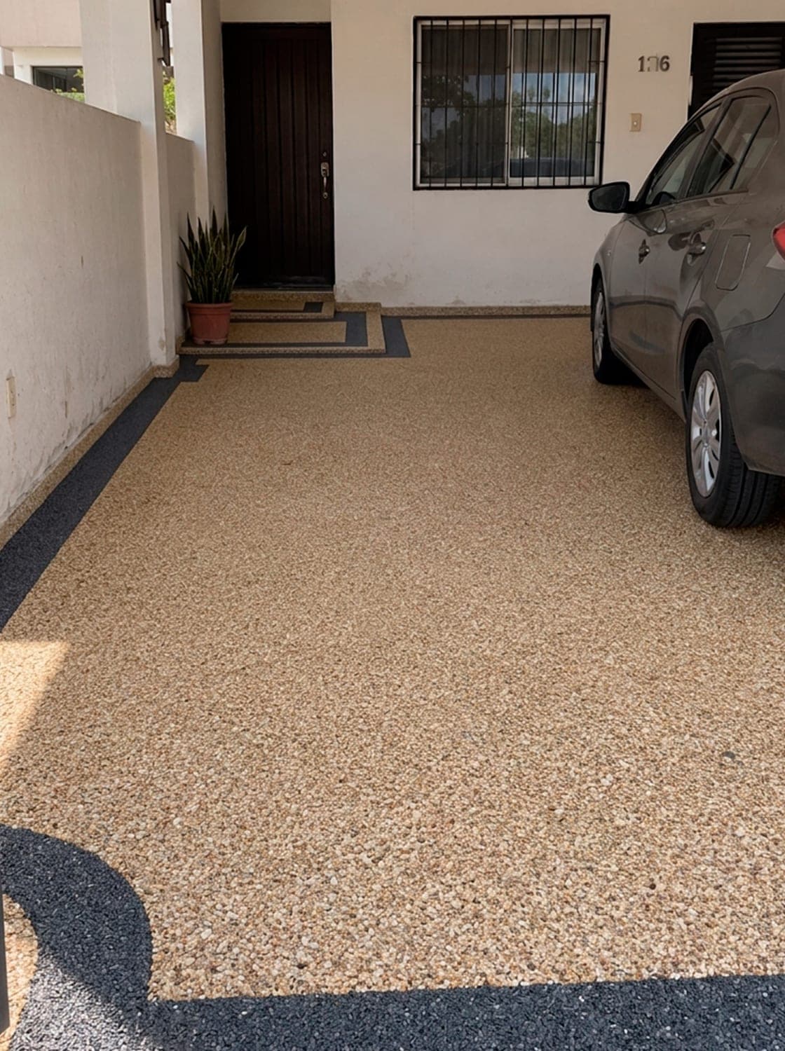 Cochera con piso de granito granulado beige y cenefa negra