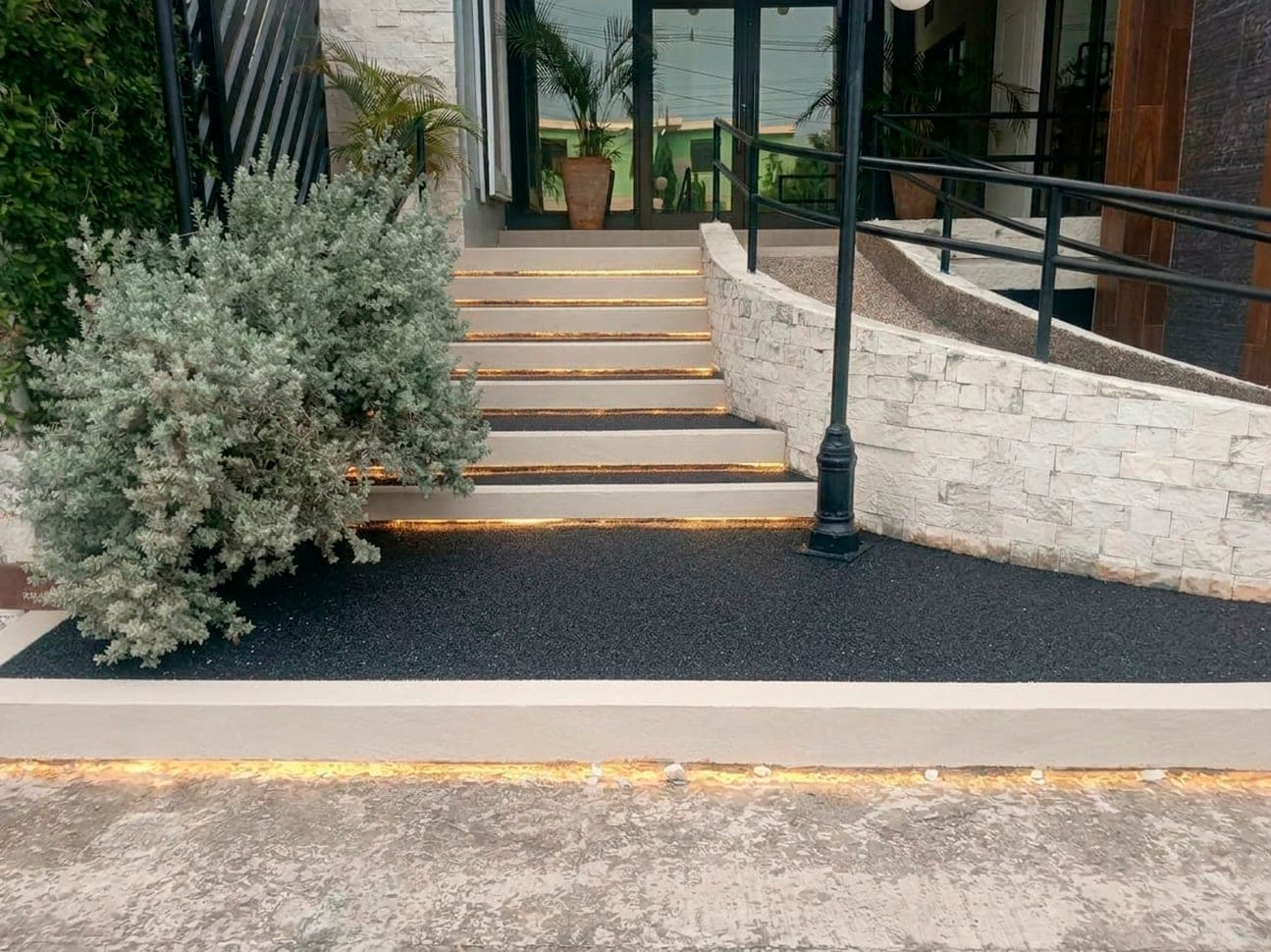 Acceso terminado con granito granulado e iluminación en los escalones