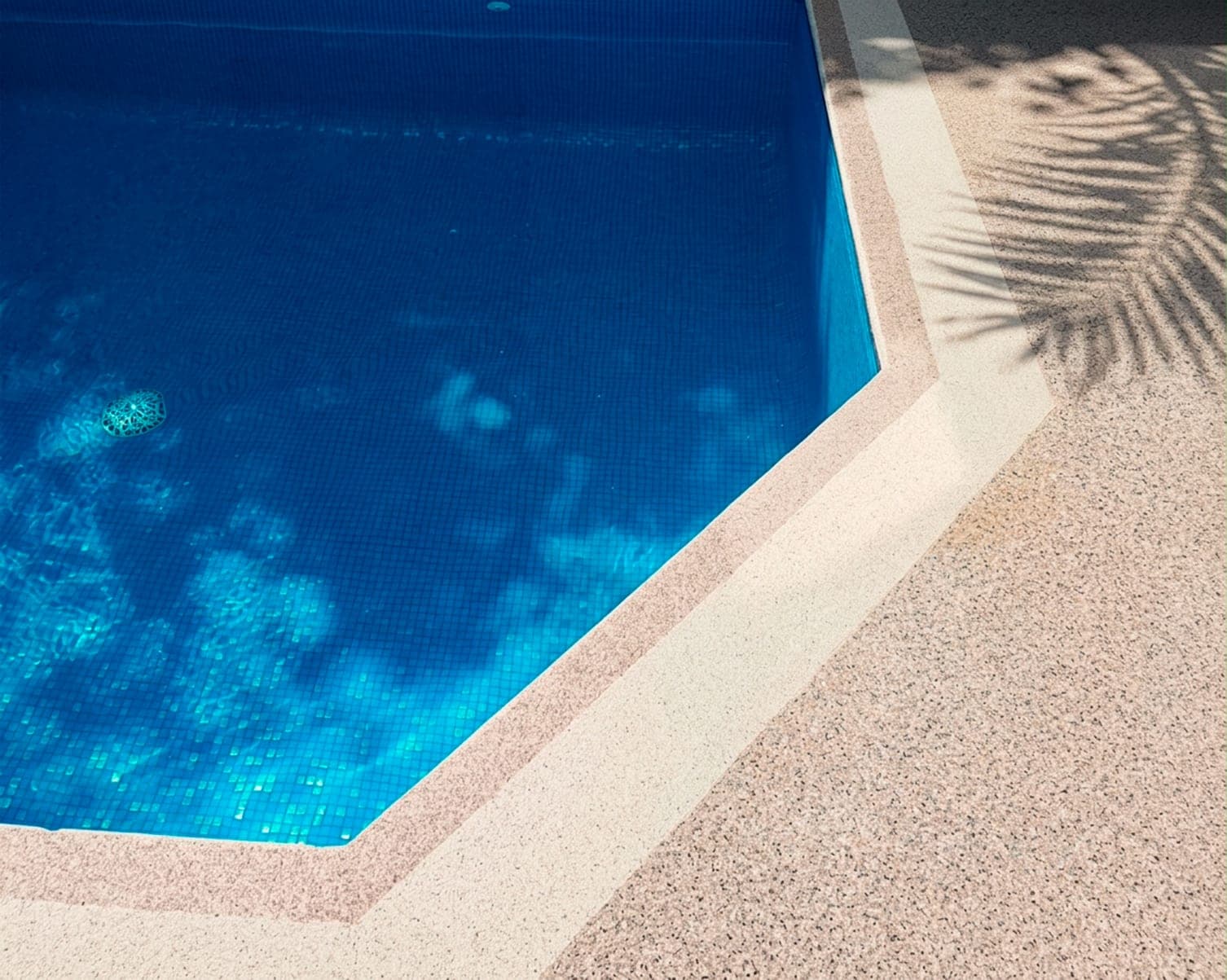 Contorno de piscina terminado con granito granulado en tono rosado